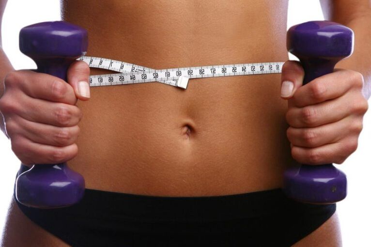 Fitness Dumbbells in the hands of a girl with a fitness